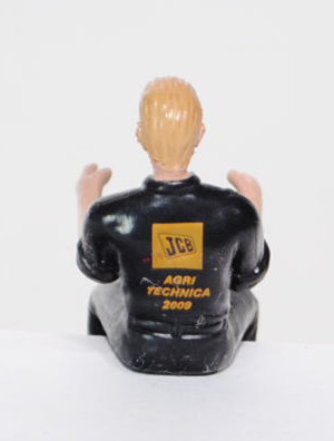 Traktorfahrer mit schwarzgrauem Overal, blonde Haare, JCB Logo auf der Brusttasche, Druck JCB / AGRI